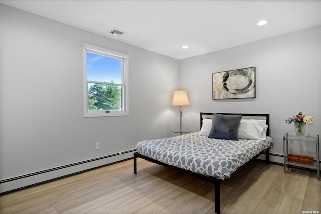 bedroom featuring a baseboard heating unit, recessed lighting, visible vents, and light wood-style floors