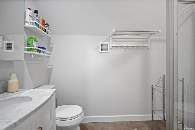 bathroom featuring toilet, vanity, visible vents, and baseboards