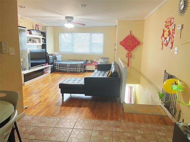 living area with ceiling fan, wood finished floors, and crown molding