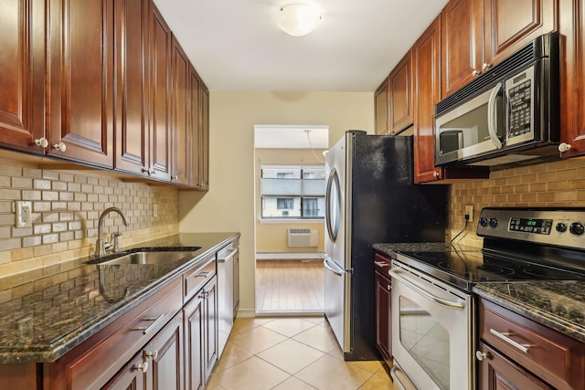 kitchen with light tile patterned flooring, a sink, stainless steel appliances, reddish brown cabinets, and backsplash