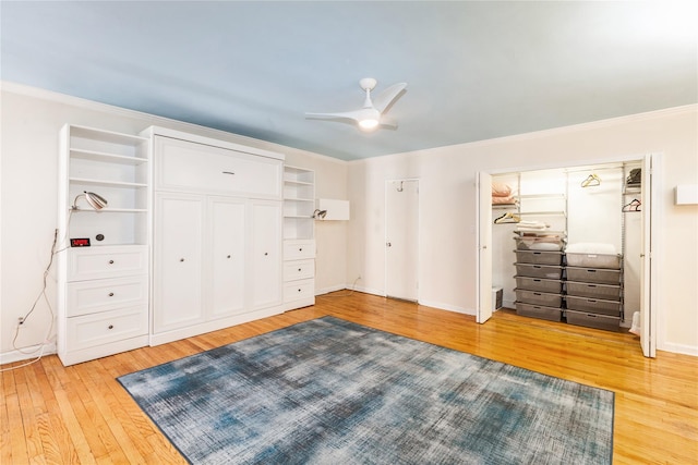 bedroom with light wood-style floors, baseboards, ornamental molding, and a ceiling fan