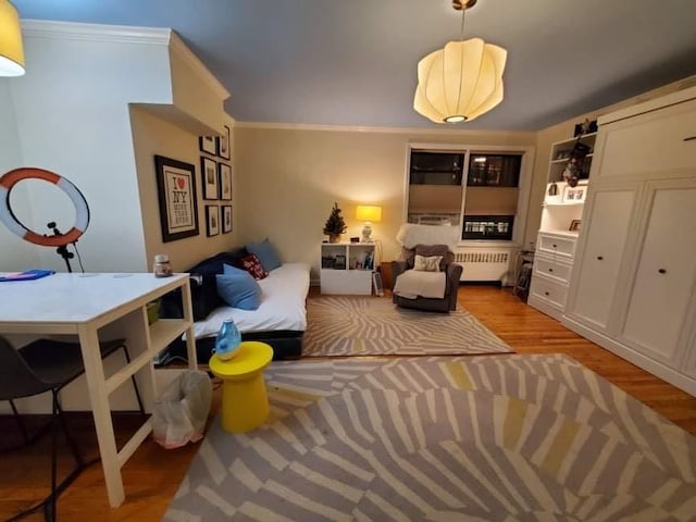 living area featuring ornamental molding, radiator heating unit, and wood finished floors