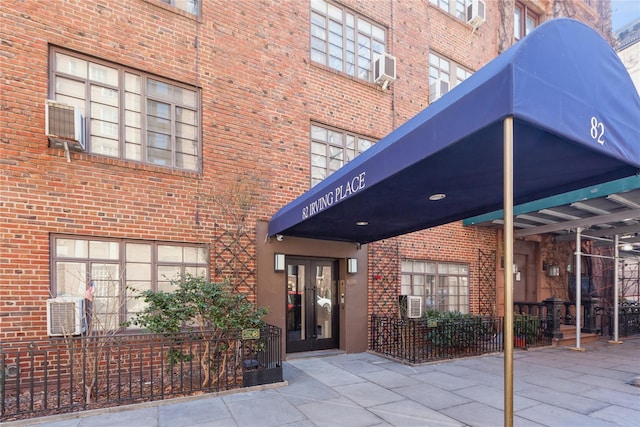 view of exterior entry featuring french doors and brick siding