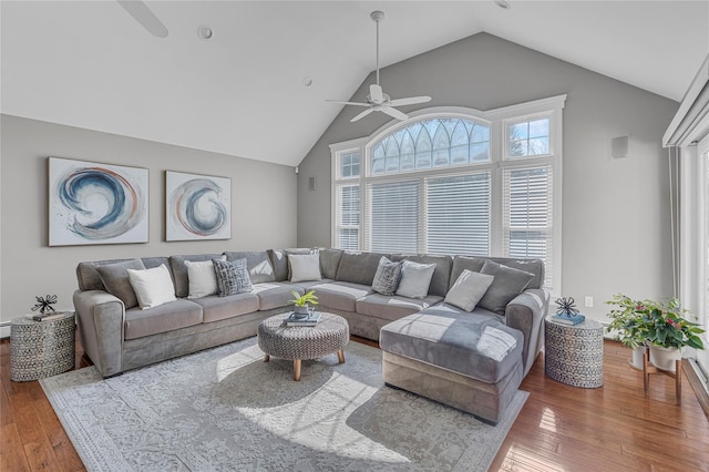 living room featuring wood-type flooring, visible vents, baseboard heating, ceiling fan, and high vaulted ceiling