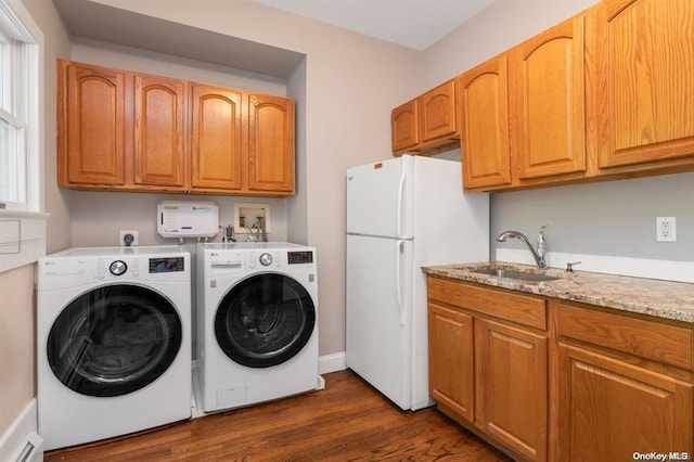 washroom with dark wood-type flooring, a baseboard radiator, washer and clothes dryer, and a sink