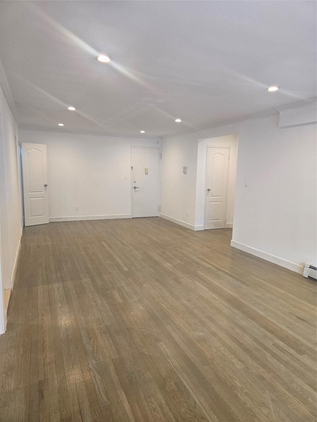 unfurnished room featuring baseboards, wood finished floors, and recessed lighting