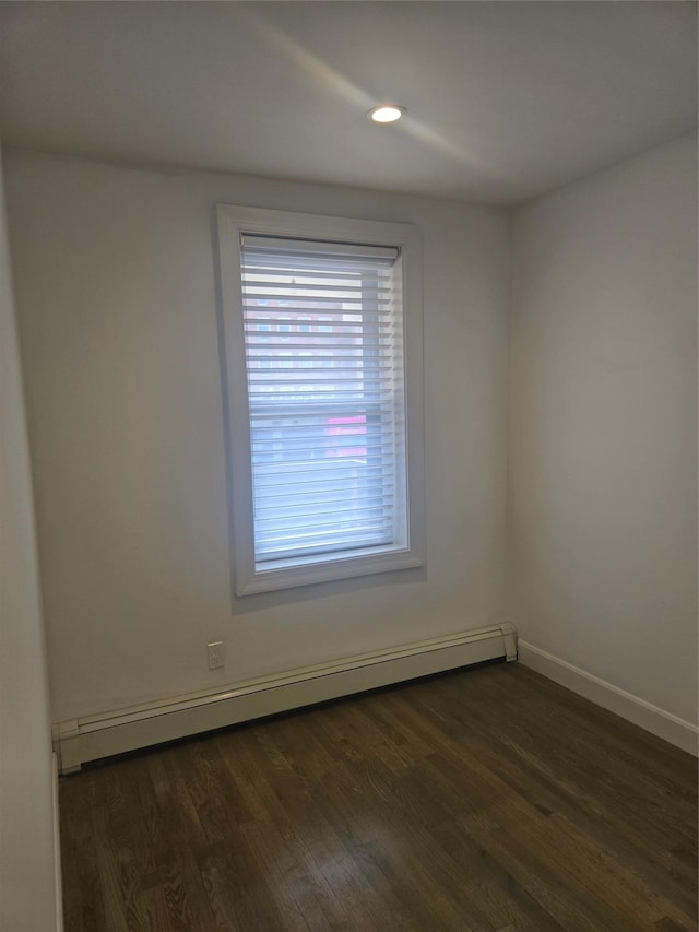 spare room featuring a baseboard radiator, baseboards, dark wood-style flooring, and recessed lighting