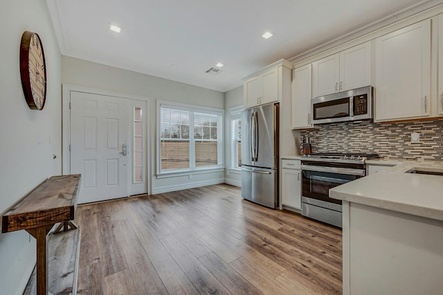 4109 Fox Hill Dr Unit 4109, Baiting Hollow, NY 11933 - kitchen with stainless steel appliances, visible vents, light countertops, backsplash, and light wood-type flooring