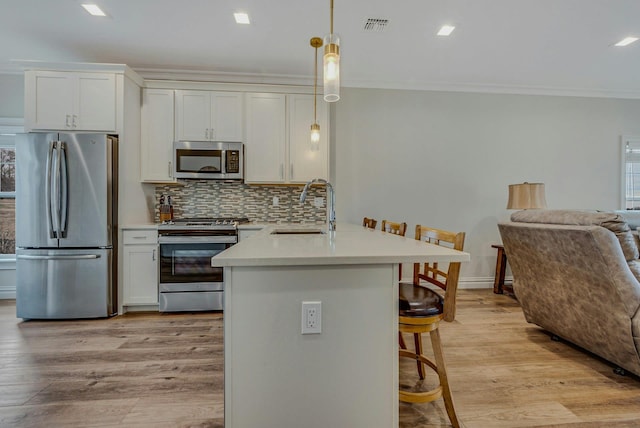 4109 Fox Hill Dr Unit 4109, Baiting Hollow, NY 11933 - kitchen featuring stainless steel appliances, a sink, visible vents, a kitchen breakfast bar, and ornamental molding