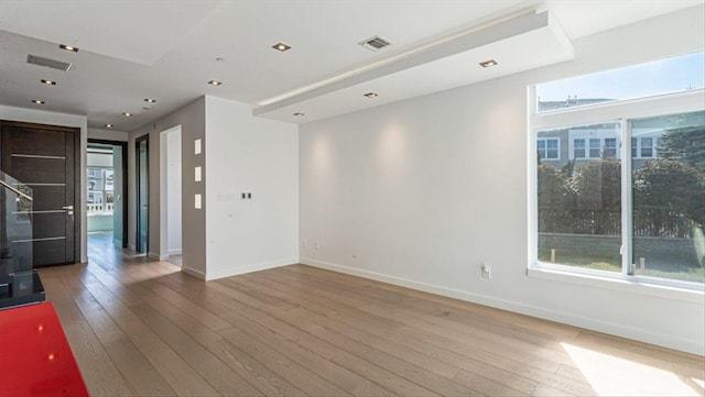 spare room featuring hardwood / wood-style floors, recessed lighting, visible vents, and baseboards