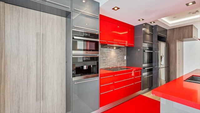 kitchen featuring appliances with stainless steel finishes, under cabinet range hood, decorative backsplash, and modern cabinets