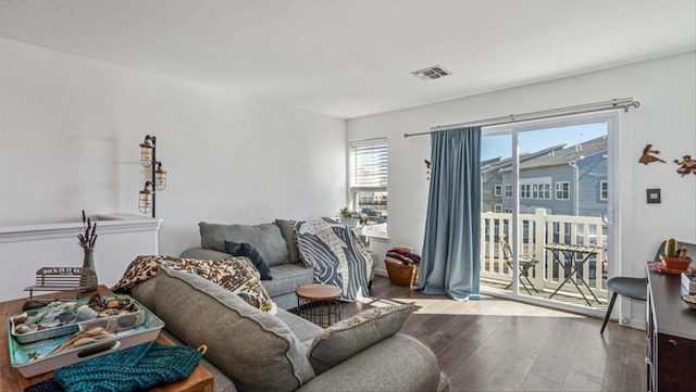 living room with hardwood / wood-style floors and visible vents