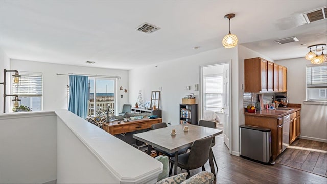 dining area featuring dark wood-style floors, plenty of natural light, and visible vents