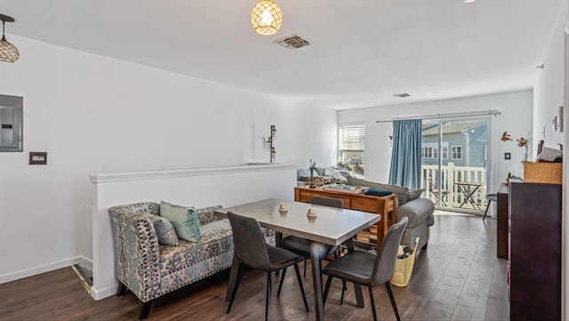 dining space with electric panel, wood finished floors, visible vents, and baseboards