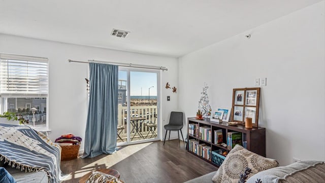 living room with visible vents, wood finished floors, and a wealth of natural light