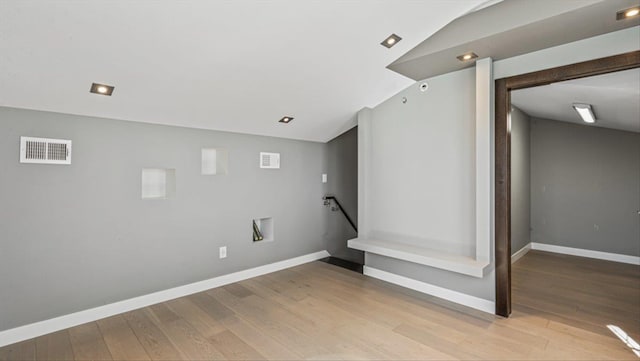 basement with light wood-type flooring, baseboards, and visible vents