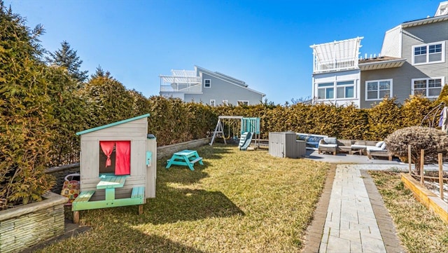 rear view of property featuring a playground and a yard