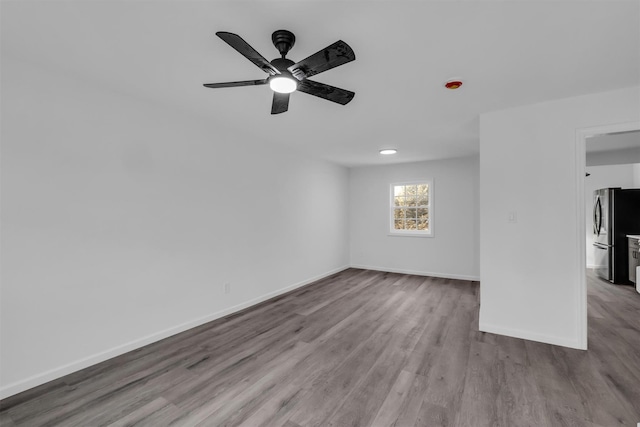 unfurnished room with ceiling fan, baseboards, and wood finished floors