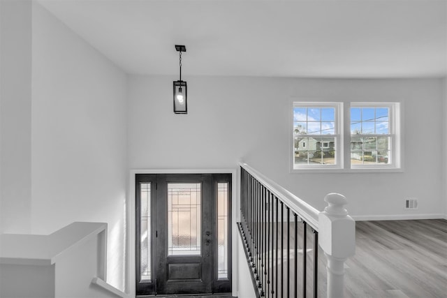 entrance foyer with visible vents, wood finished floors, and baseboards