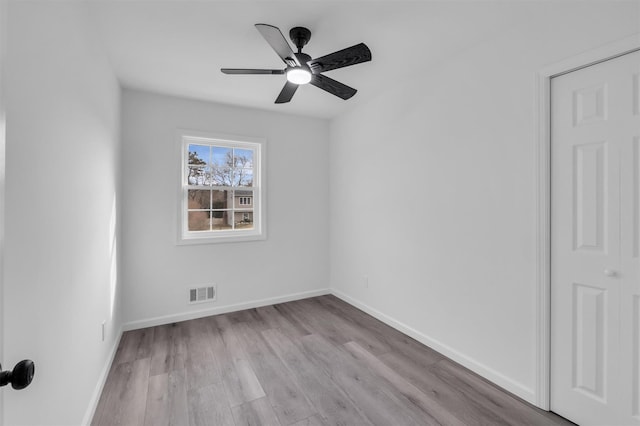 spare room with visible vents, ceiling fan, baseboards, and wood finished floors