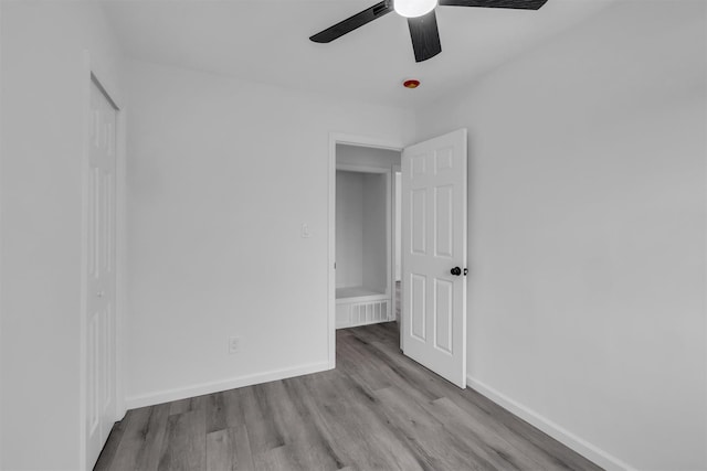 unfurnished bedroom featuring visible vents, ceiling fan, baseboards, wood finished floors, and a closet