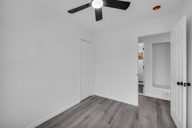 unfurnished bedroom with visible vents, ceiling fan, baseboards, and wood finished floors