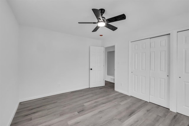 unfurnished bedroom with ceiling fan, baseboards, and wood finished floors