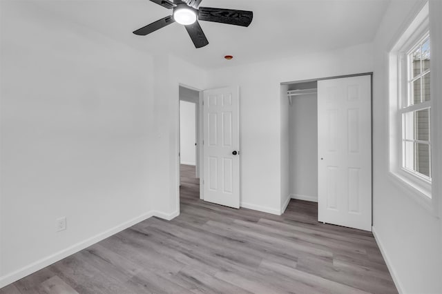 unfurnished bedroom featuring a closet, baseboards, and wood finished floors