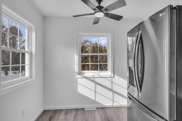 kitchen featuring light wood-type flooring, baseboards, ceiling fan, and stainless steel refrigerator with ice dispenser