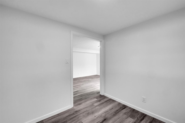 spare room featuring baseboards and wood finished floors