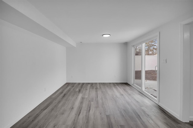 unfurnished room featuring baseboards and wood finished floors