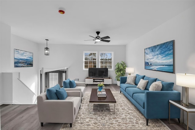 living room featuring baseboards, a ceiling fan, and wood finished floors