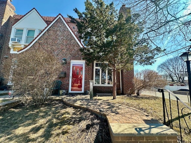 view of front facade with fence and brick siding