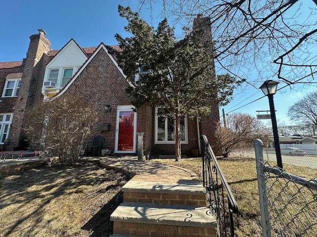 view of front of house with brick siding and fence