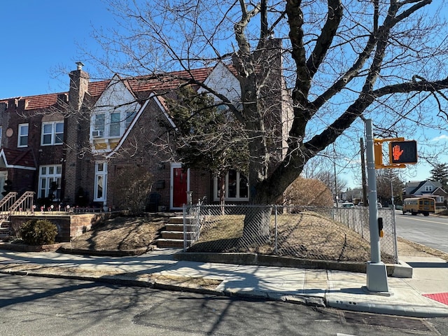 view of front of house featuring a fenced front yard, brick siding, and a chimney