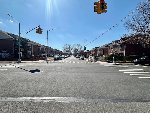 view of road with sidewalks, traffic lights, a residential view, and curbs