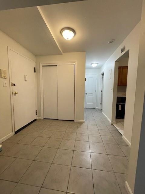 foyer featuring light tile patterned flooring and baseboards