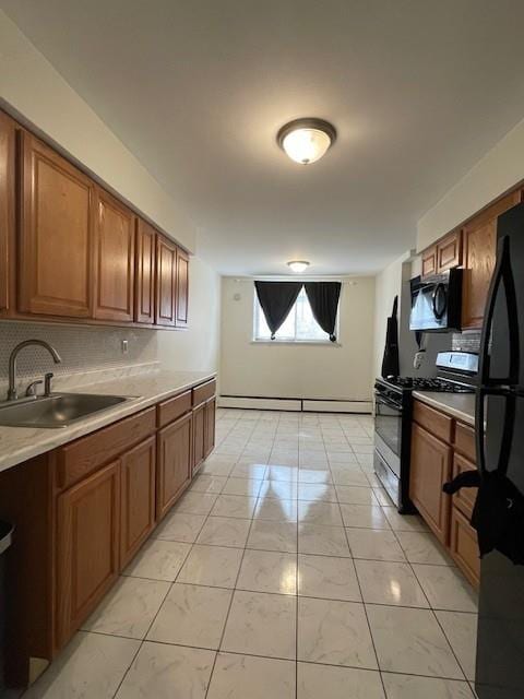 kitchen with black appliances, backsplash, a sink, and light countertops