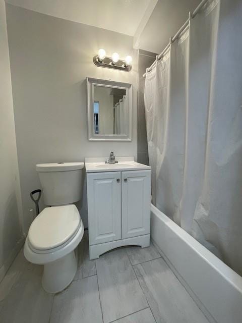 full bathroom featuring toilet, marble finish floor, shower / tub combo with curtain, and vanity