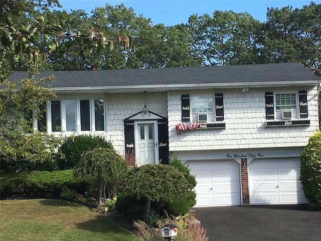 bi-level home featuring aphalt driveway and a garage