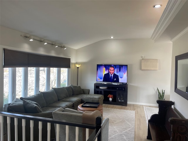 living area featuring baseboards, lofted ceiling, crown molding, light wood-type flooring, and track lighting