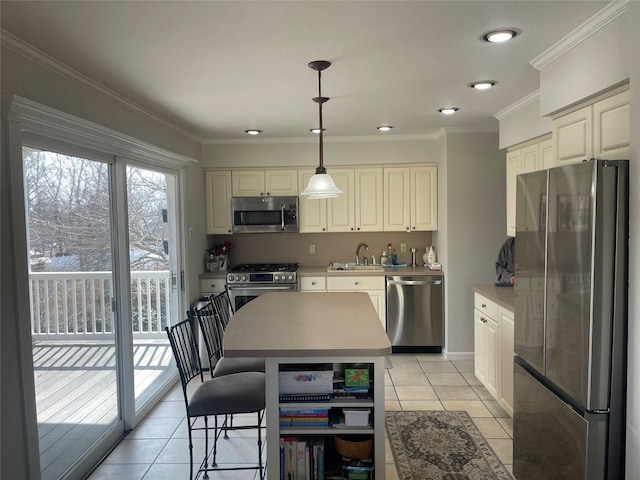 kitchen featuring light tile patterned floors, appliances with stainless steel finishes, ornamental molding, hanging light fixtures, and a sink