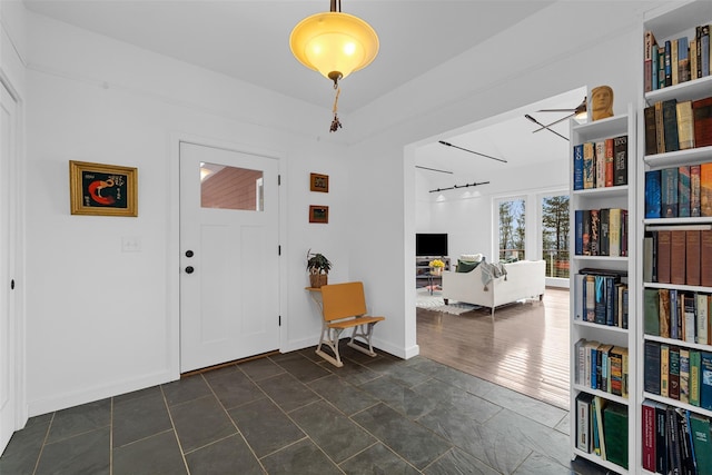 entrance foyer with a ceiling fan and baseboards