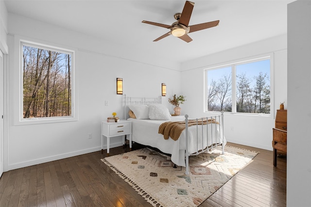 bedroom featuring wood-type flooring, multiple windows, and baseboards