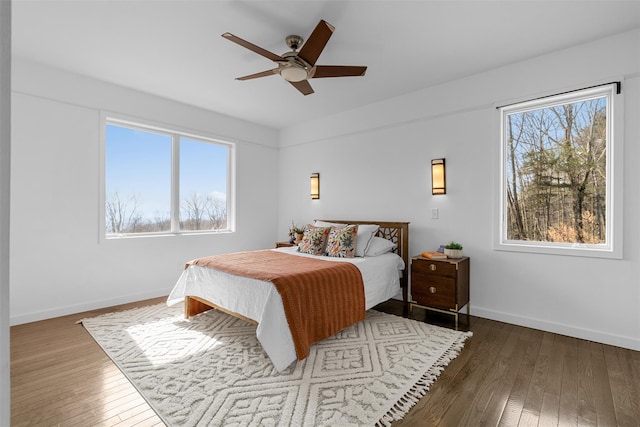 bedroom with hardwood / wood-style flooring, ceiling fan, and baseboards