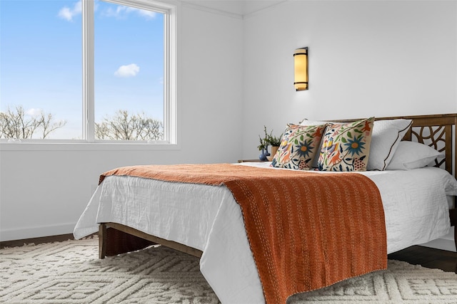 bedroom featuring wood finished floors and baseboards