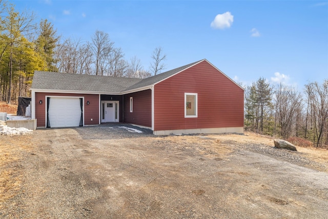 view of front of property with an attached garage, driveway, and a shingled roof