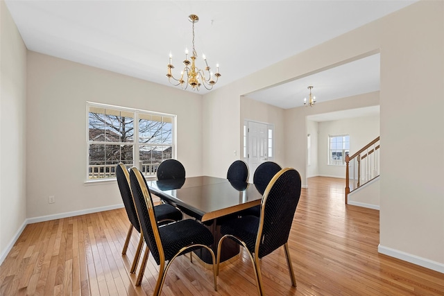 dining room with an inviting chandelier, light wood-style flooring, stairs, and baseboards