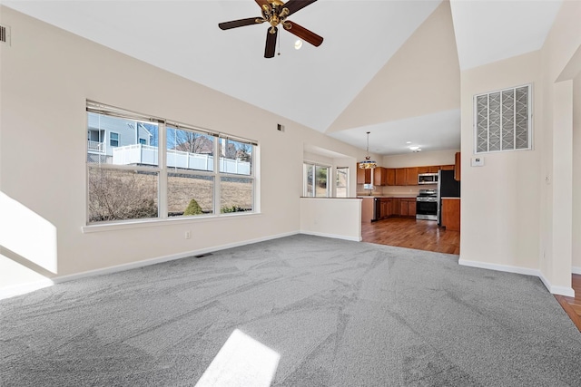 unfurnished living room featuring carpet floors, visible vents, high vaulted ceiling, and baseboards