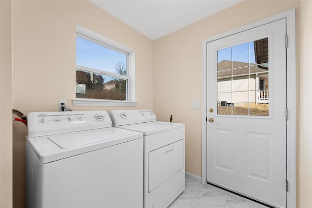 clothes washing area featuring laundry area, washing machine and dryer, marble finish floor, and baseboards